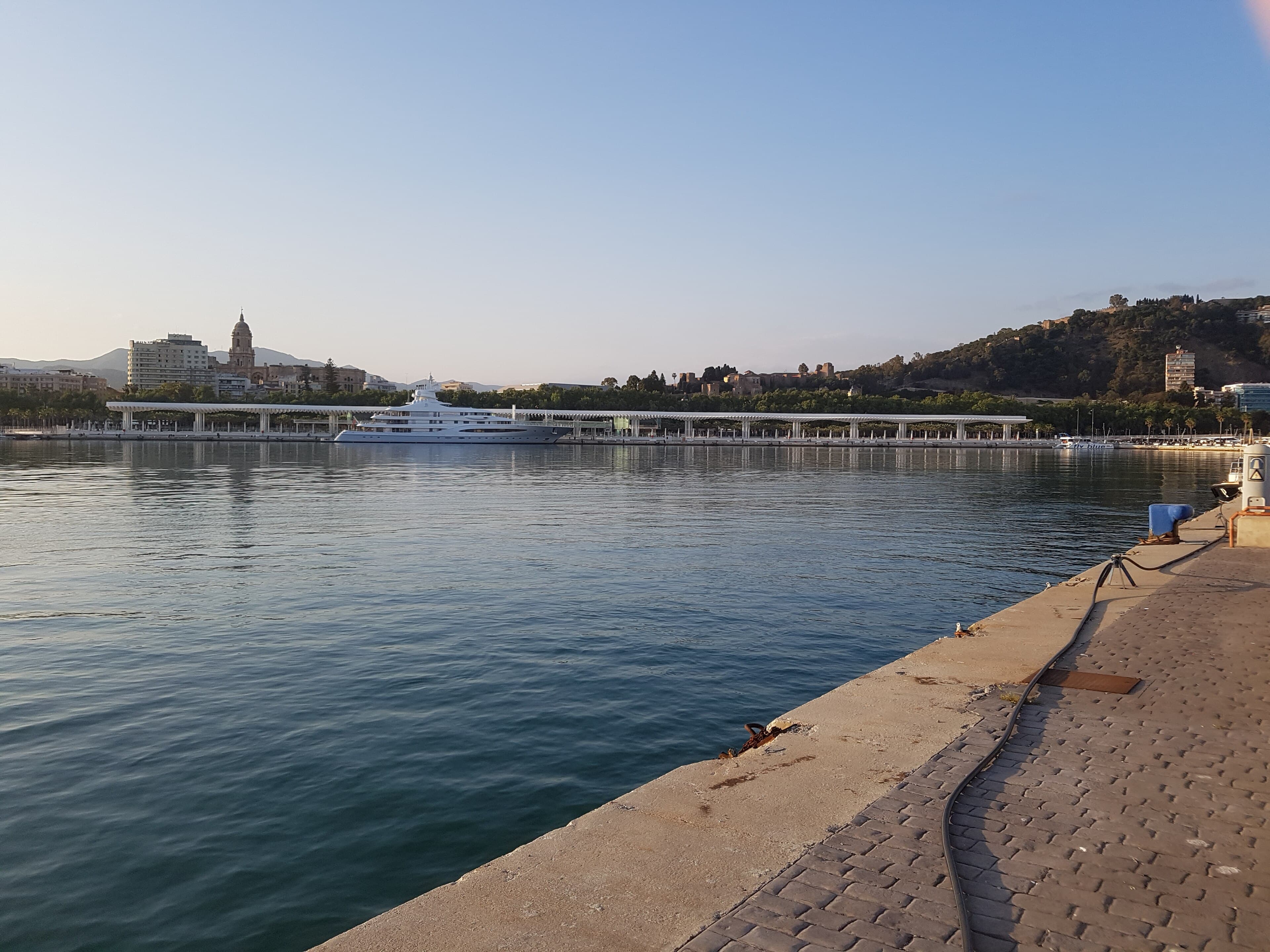 The port of Málaga at dusk, with the city and the Cathedral behind