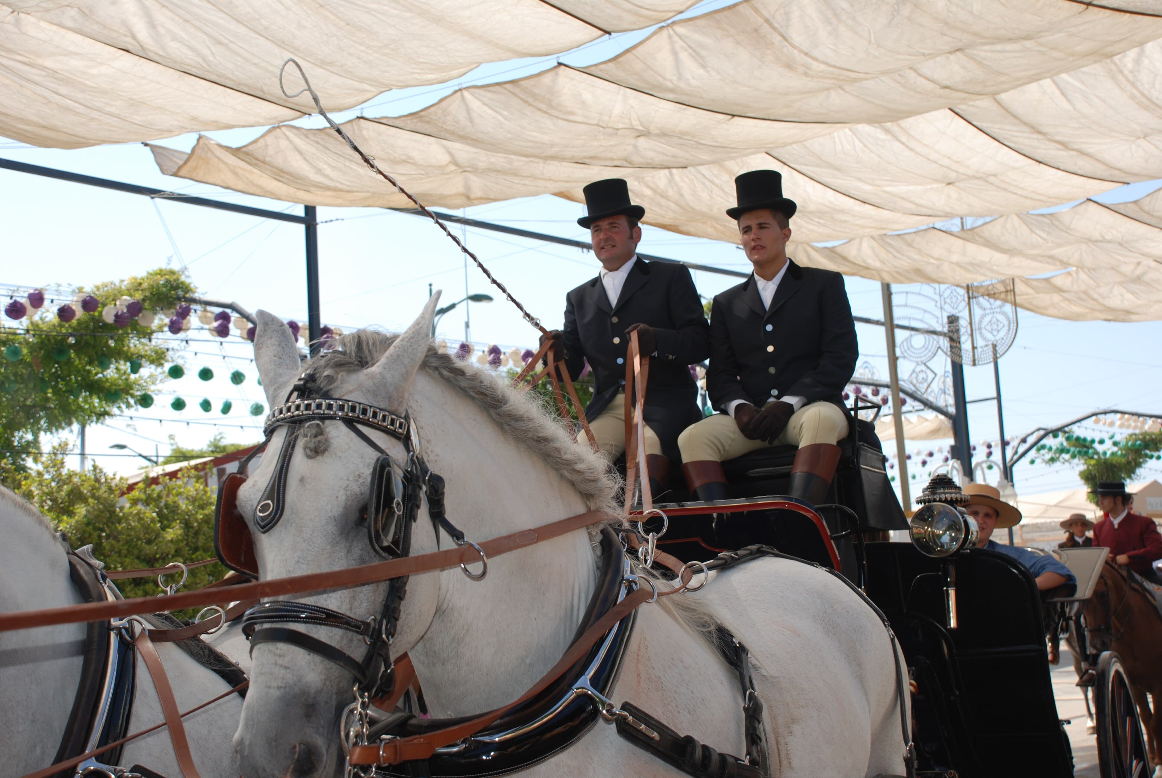 Coche de caballos con trajes tradicionales en la Feria de Málaga